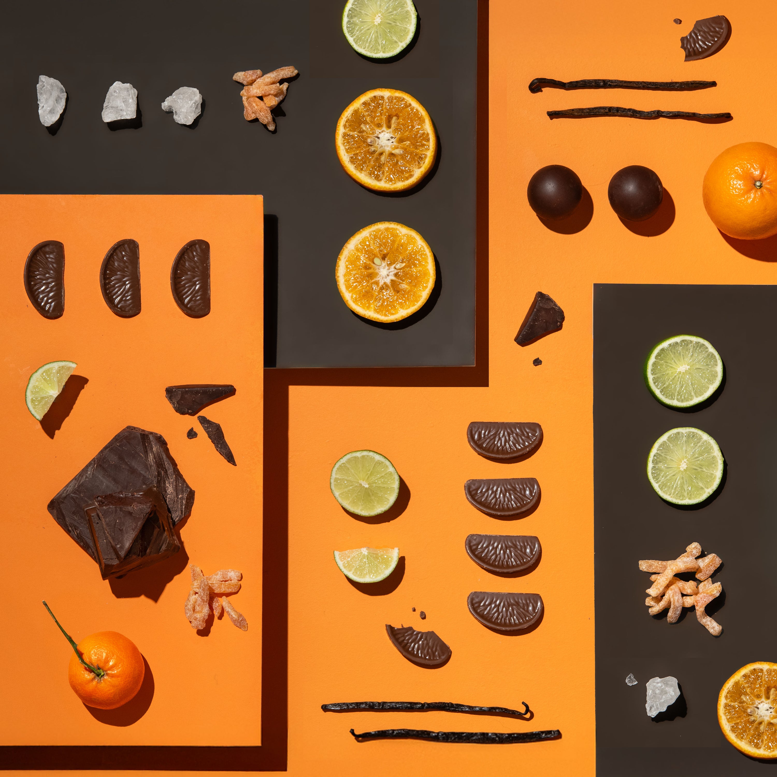 Arrangement of oranges, limes, and chocolate pieces on an orange and black background