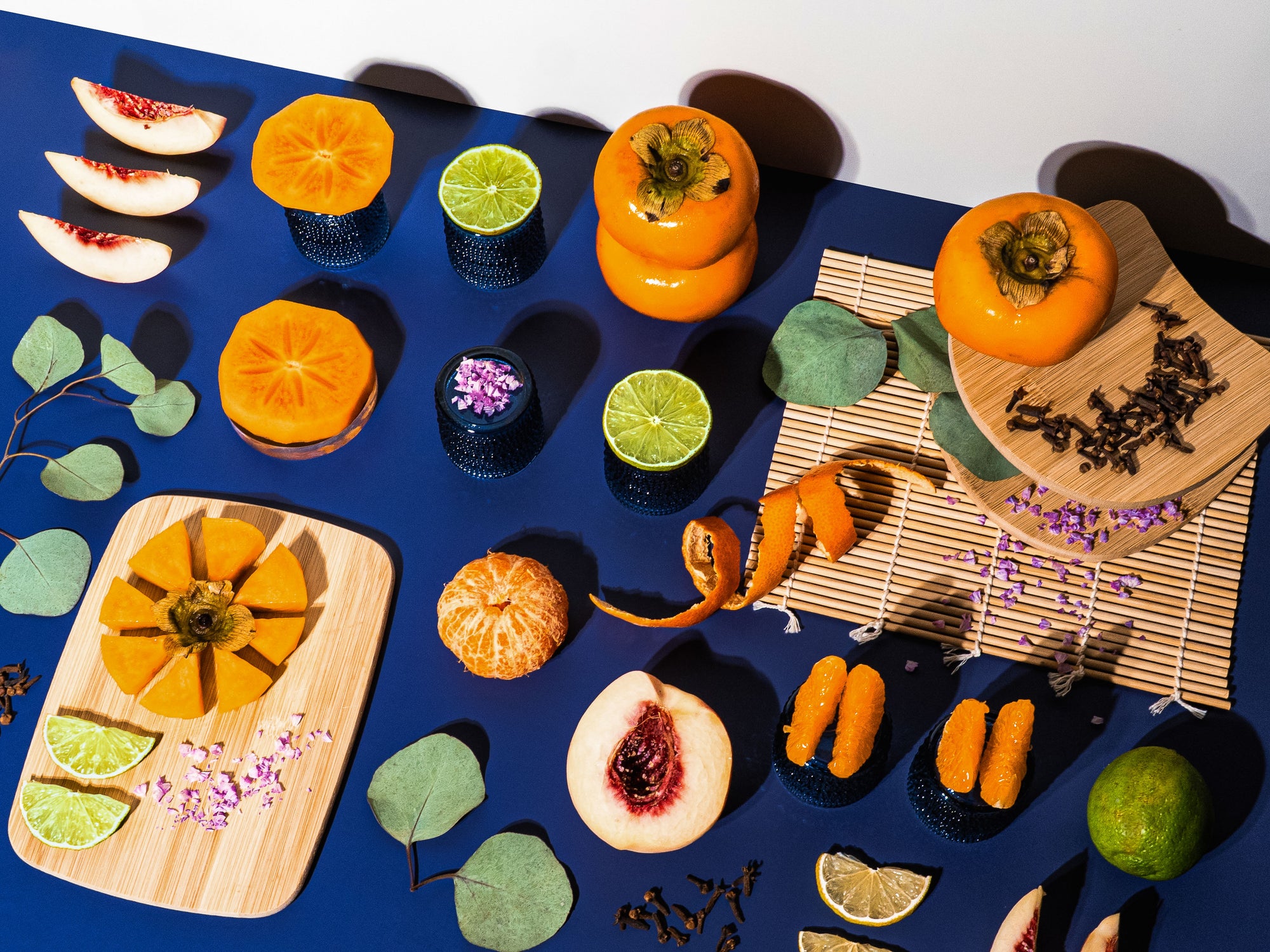 Assorted fruits and desserts on a blue surface with decorative elements.