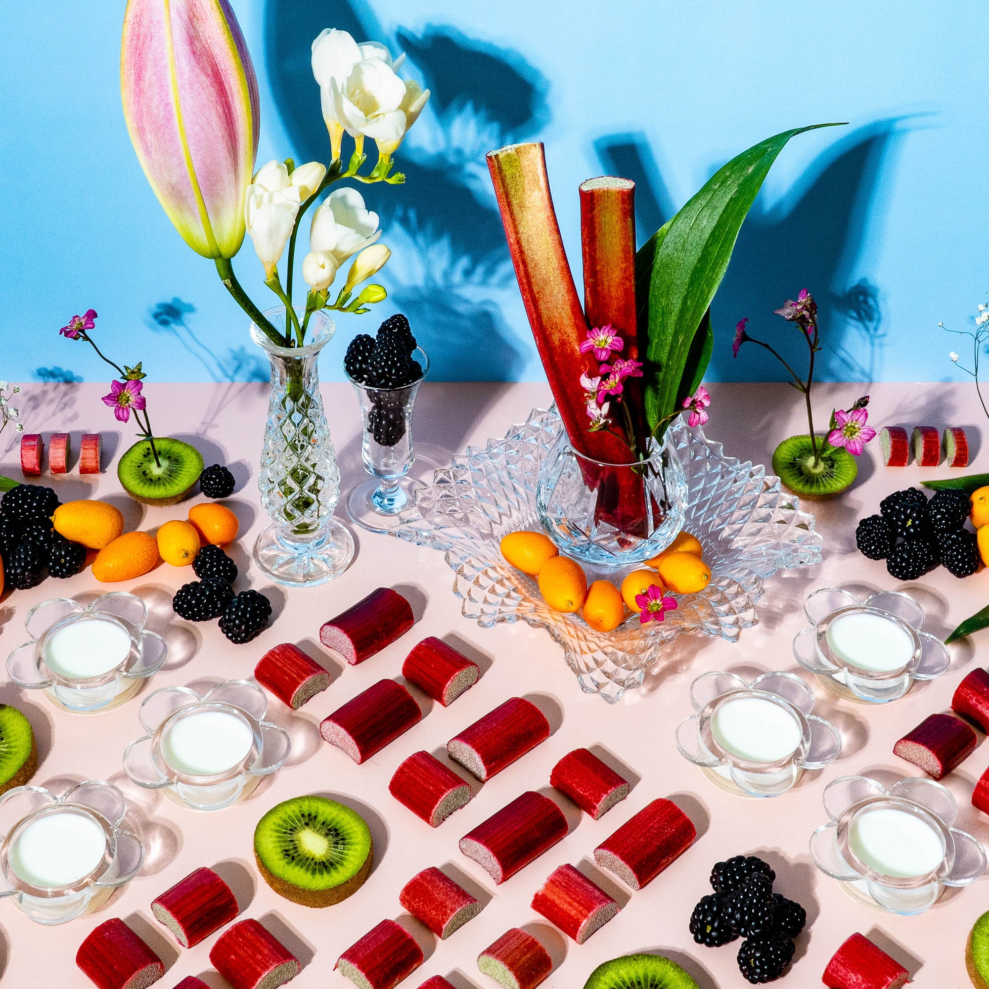 Assorted fruits and jelly shots on a table with a blue background