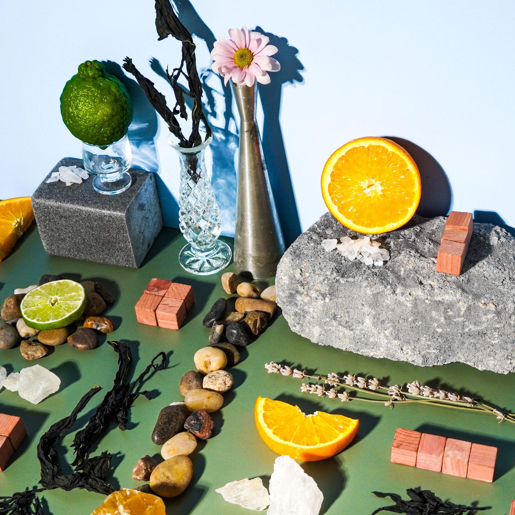 An assortment of objects related to citrus fruits and rocks, likely used for creating fragrance oils. This includes citrus fruits like oranges and limes, rocks, and other decorative items.