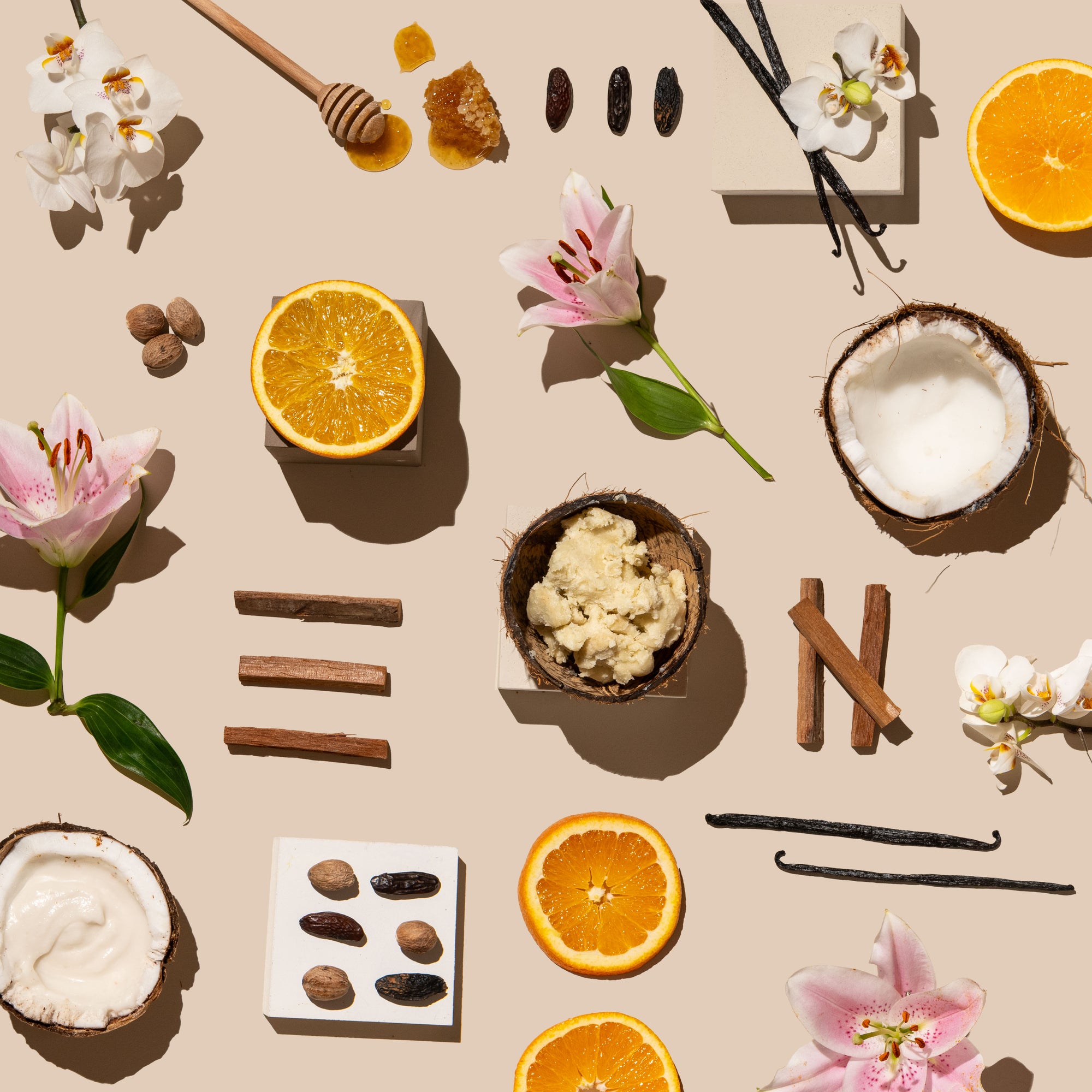 Arrangement of fruits, flowers, and spices on a beige background