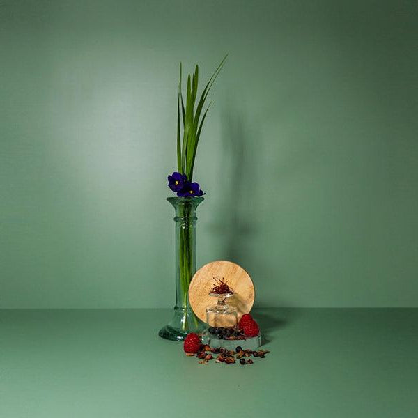 Violets high in a vase with saffron on a green background